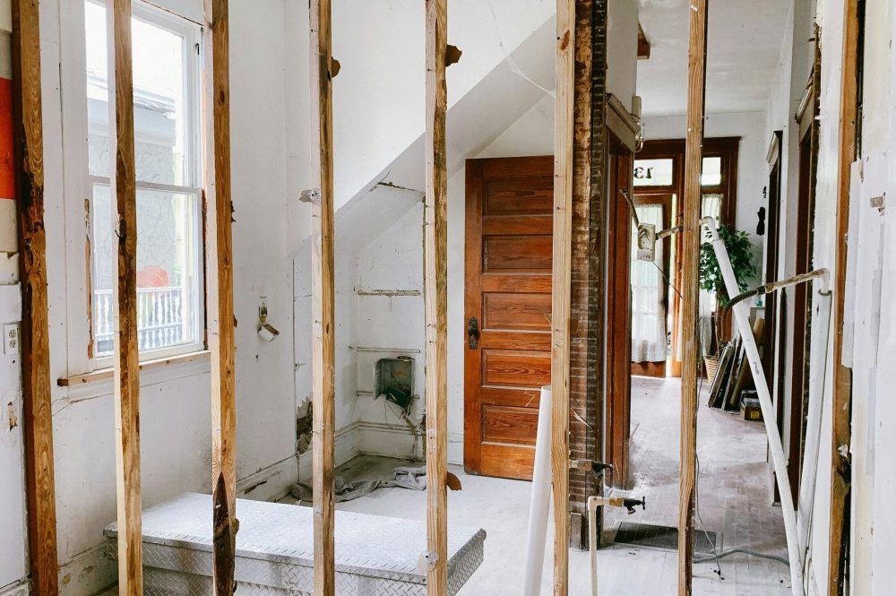 pexels photo 4756489 4756489 Interior view of a home under renovation with exposed wooden beams and door.